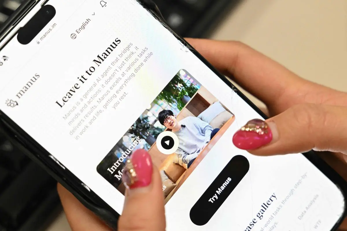 A photo illustration taken in Beijing on March 11, 2025 shows a mobile phone displaying an introduction screen for the AI assistant tool Manus, released by Chinese startup Butterfly Effect