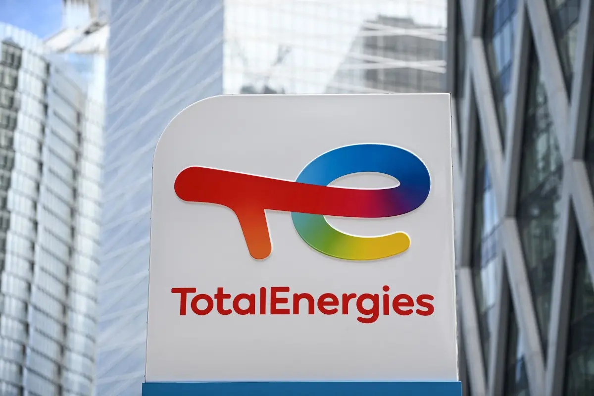 This photograph shows the new TotalEnergies logo during its unveling ceremony, at a charging station in La Defense on the outskirts of Paris