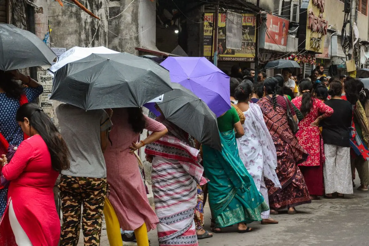 Women voters stand in a queue in the rain at a polling booth during the second phase of voting to cast their votes at Serampore in Hooghly. | Representational Image: ANI
