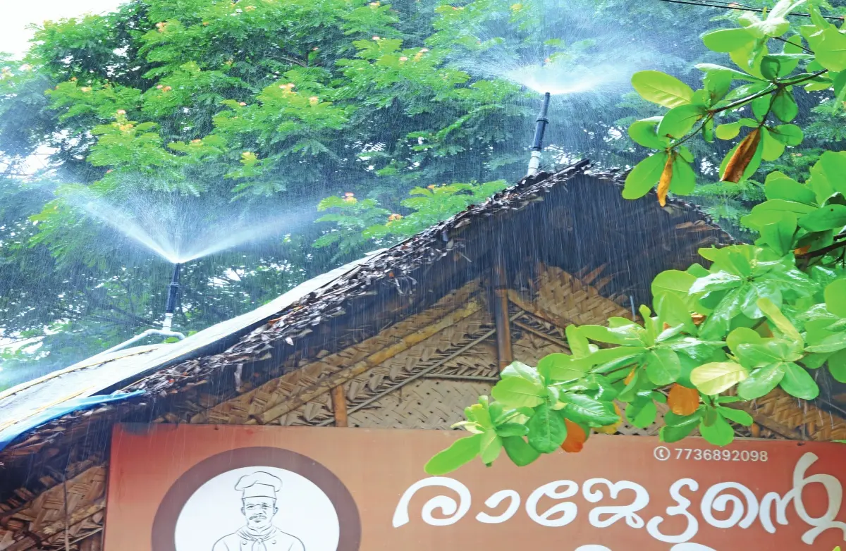 യാക്കരയിലെ 'രാജേട്ടന്റെ കട' എന്ന ഹോട്ടലിന് മുകളില് സ്പ്രിംഗ്ലര് വഴി ഒരുക്കിയിരിക്കുന്ന കൃത്രിമമഴ. ചൂട് അസഹ്യമായതോടെയാണ് ഓലപ്പുരയ്ക്കുമുകളില് പ്ലാസ്റ്റിക് ഷീറ്റ് വിരിച്ച് സ്പ്രിംഗ്ലര് സ്ഥാപിച്ചത്