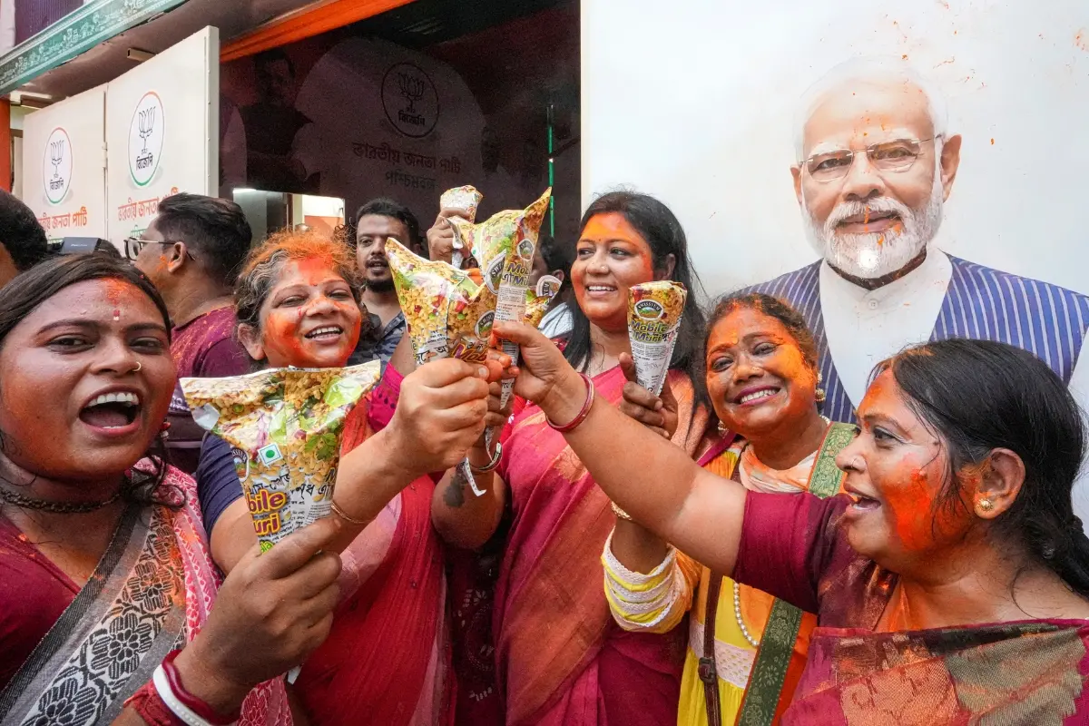 BJP supporters eat 'Jhalmuri' amid celebrations of party's lead during vote tabulation on the day of West Bengal Assembly election results | Photo: PTI