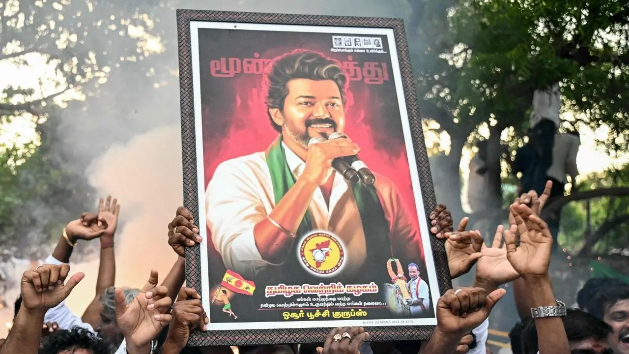വിജയ്യുടെ ചിത്രവുമായി ആഹ്ലാദപ്രകടനം നടത്തുന്ന ടിവികെ പ്രവർത്തകർ | Photo: AFP