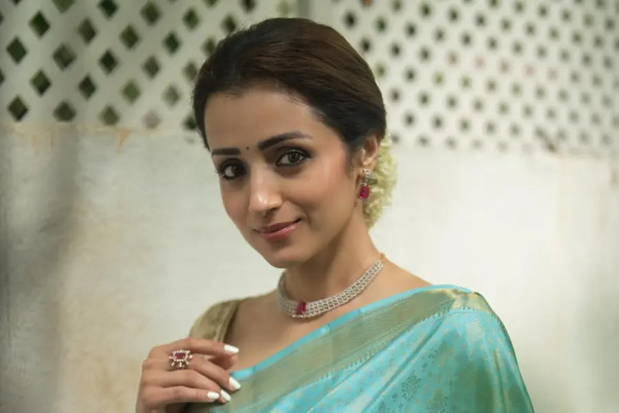 Actress Trisha Krishnan in a traditional light blue silk saree and gold jewelry, after attending the swearing-in ceremony of Chief Minister Vijay in Chennai
