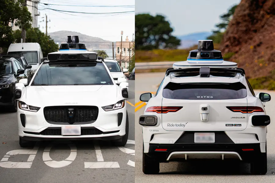 A Waymo self-driving car equipped with sensors and cameras navigating a narrow street in East London where residents have complained about loud alarms