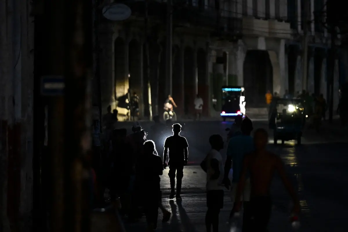 People walk on a street during a blackout in Havana, Ciba.| Photo: AFP