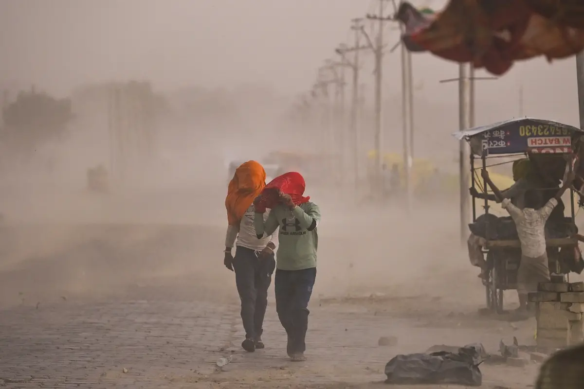 Commuters make their way through a dust storm, in Prayagraj, Uttar Pradesh.| Photo: PTI