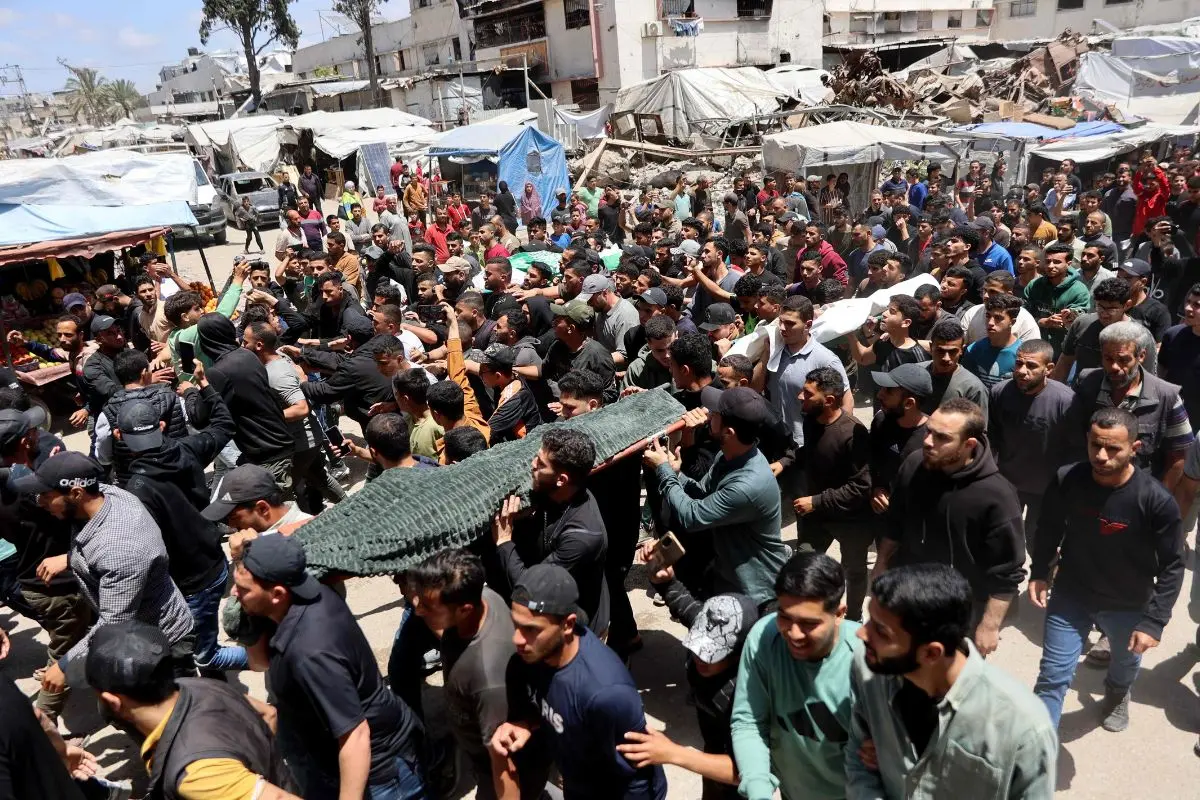 Palestinian mourners carry the bodies of Ezzedine Al-Haddad, the slain chief of the Qassam Brigades -- the armed wing of the Palestinian movement Hamas, his wife and daughter, all killed in an overnight Israeli strike, during their funeral in Gaza City on May 16, 2026. (Photo by Omar AL-QATTAA / AFP)