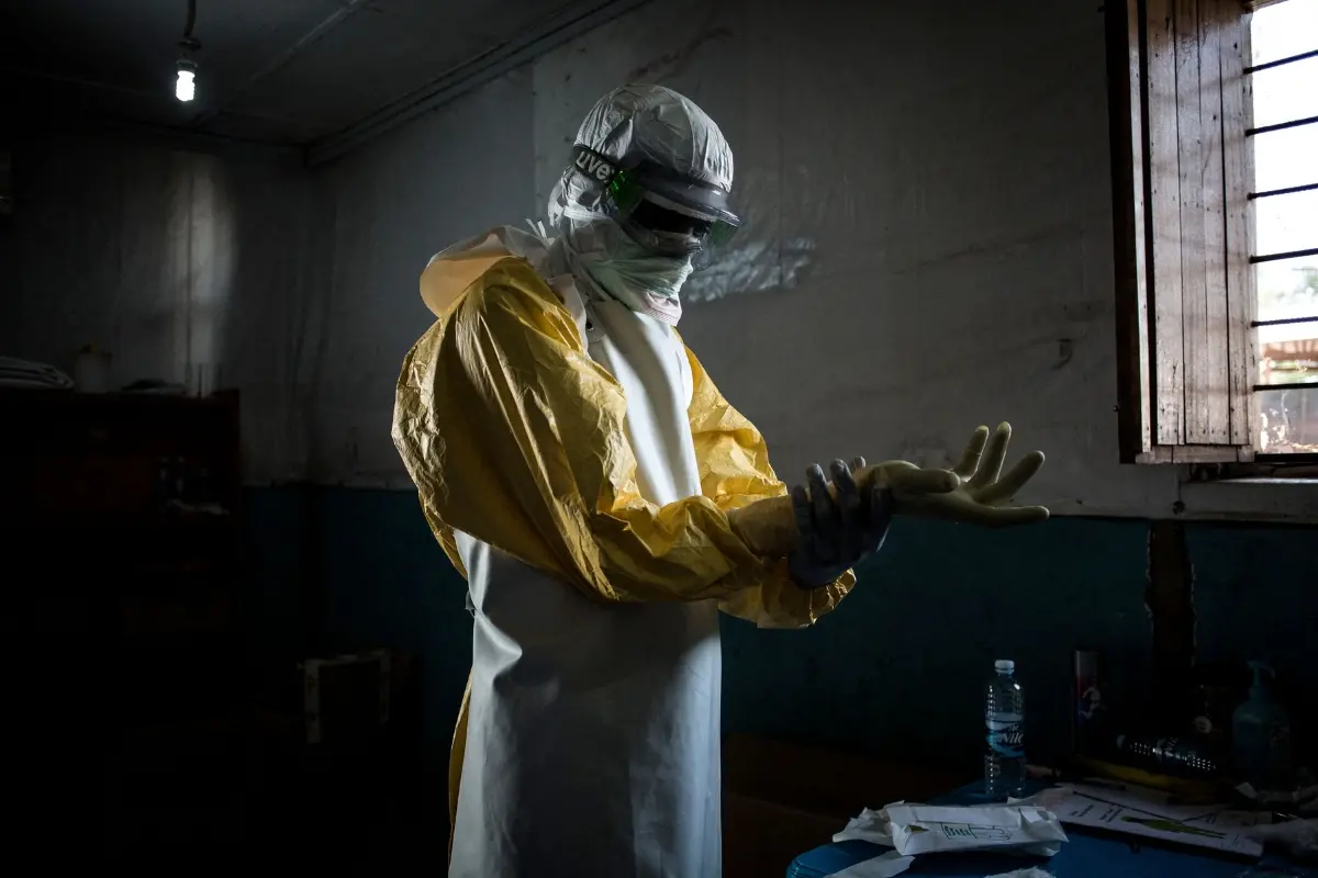 A health worker puts on his personal protective equipment (PPE) before entering the red zone of a MSF (Doctors Without Birders) supported Ebola Treatment Centre in Congo.| Photo: AFP