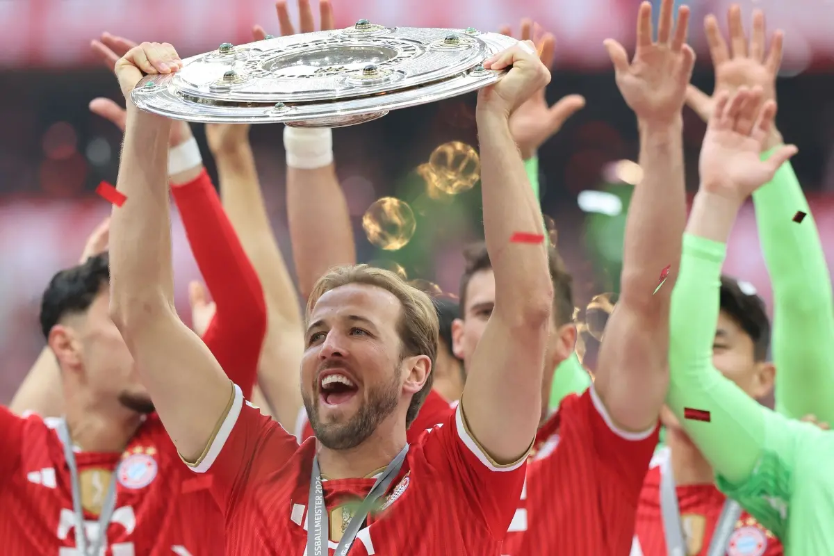 Bayern Munich's English forward #09 Harry Kane raises celebrates and raises the Bundesliga trophy after winning the German first division Bundesliga football match between FC Bayern Munich and FC Cologne | Photo: AFP