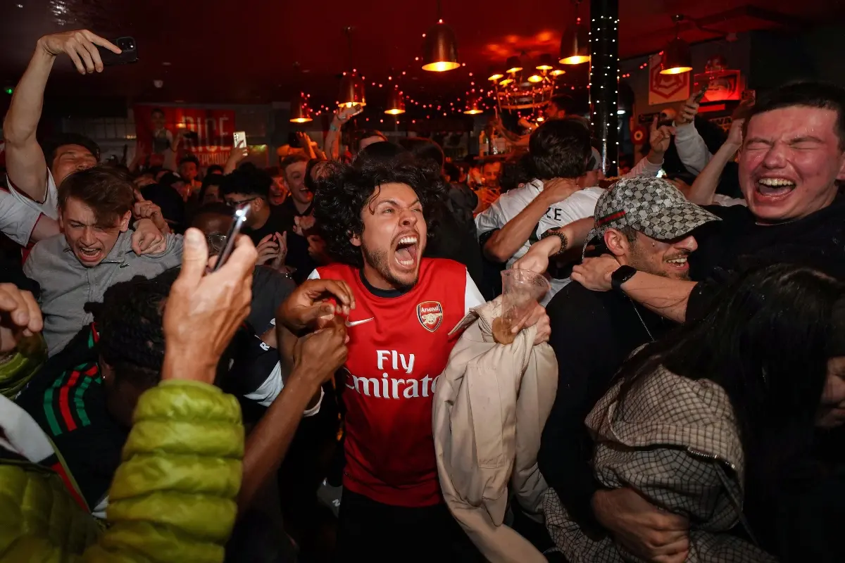Arsenal supporters celebrate in a pub near the Arsenal stadium after Arsenal's soccer team won the Premier League title in London | Photo: AP