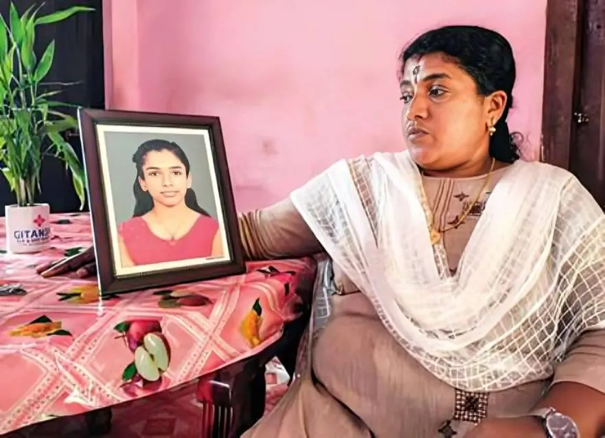Rajani beside the photograph of her late daughter, Abhirami.