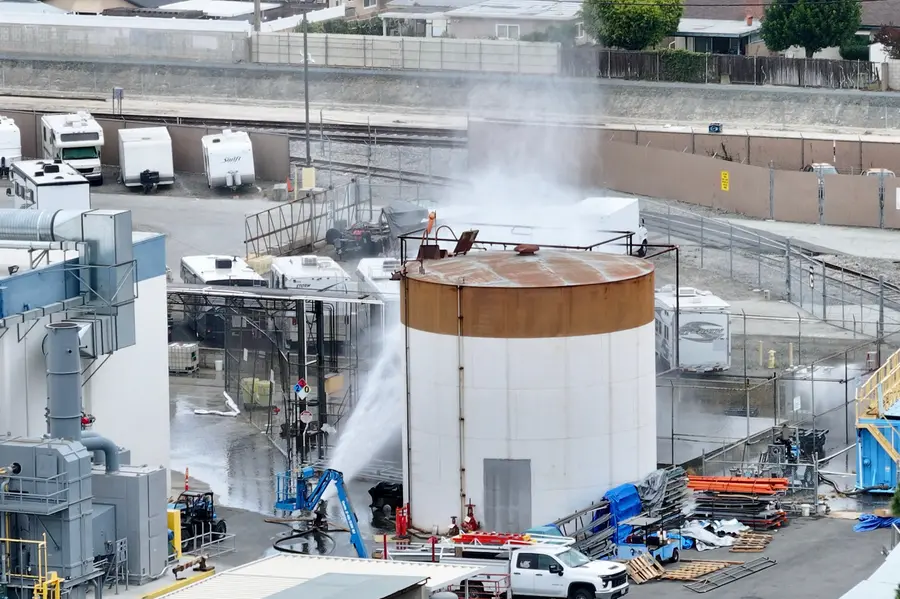 Water is sprayed on a tank that overheated at an aerospace plant in Garden Grove, California
