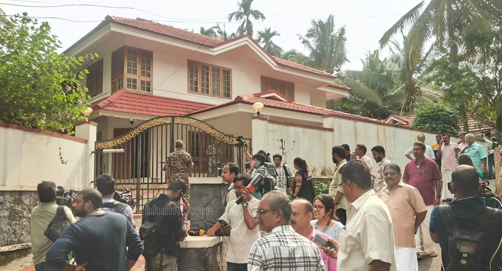 പിണറായിയിൽ പ്രതിപക്ഷ നേതാവ് പിണറായി വിജയന്റെ വീട്ടിൽ കേന്ദ്രസേനയുടെ കാവലിൽ റെയ്സ് നടക്കുമ്പോൾ എത്തിയവർ | ഫോട്ടോ - സി. സുനിൽകുമാർ / മാതൃഭൂമി