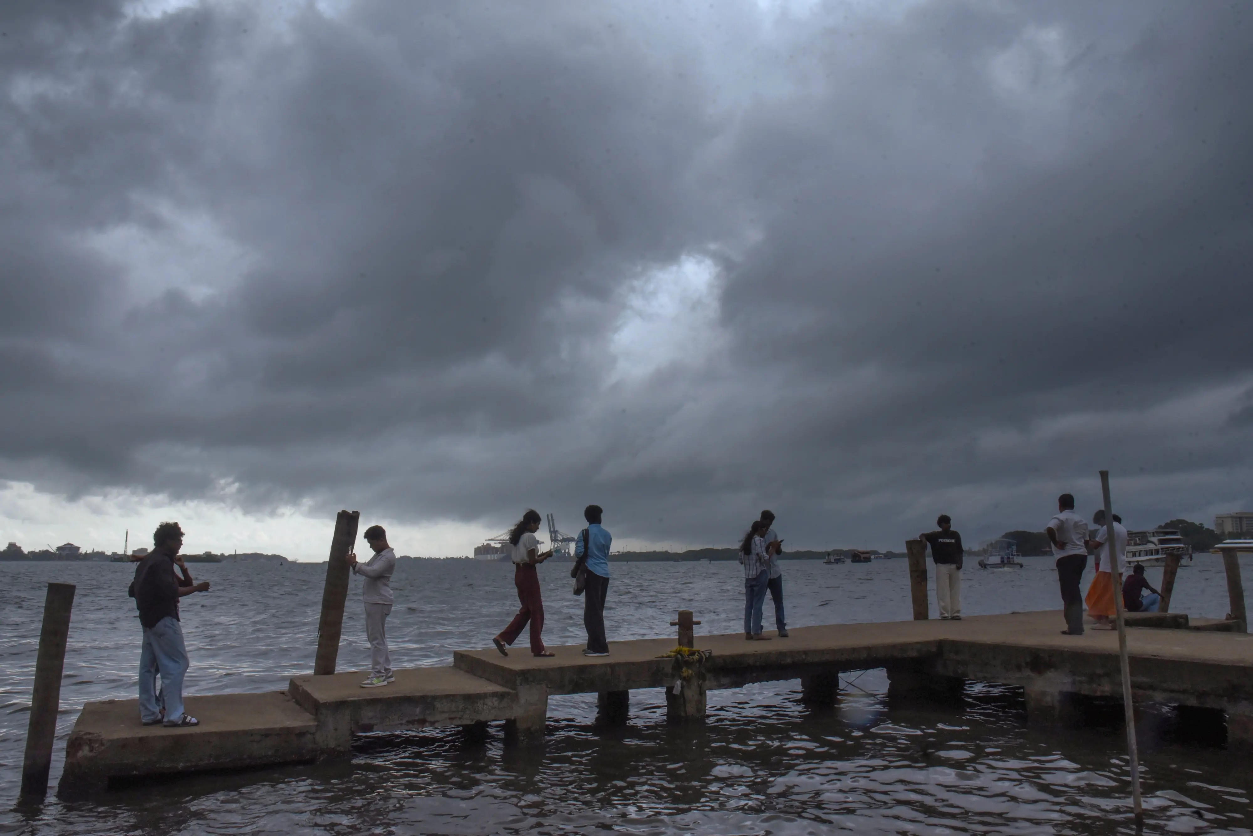 Visitors at the Marine Drive on a rainy afternoon in Kochi | PTI