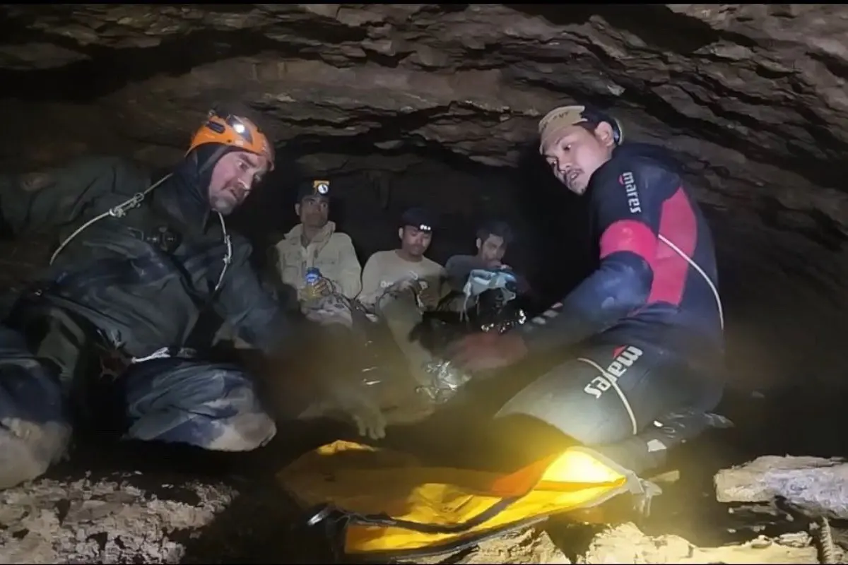 This screengrab made from handout video footage taken on May 29, 2026, and provided by Metta Tham Rescue Kalasin, shows a rescue team freeing one of seven men (L) trapped inside a semi-submerged cave in central Xaysomboun province, northeast of the capital Vientiane (Photo: AFP)