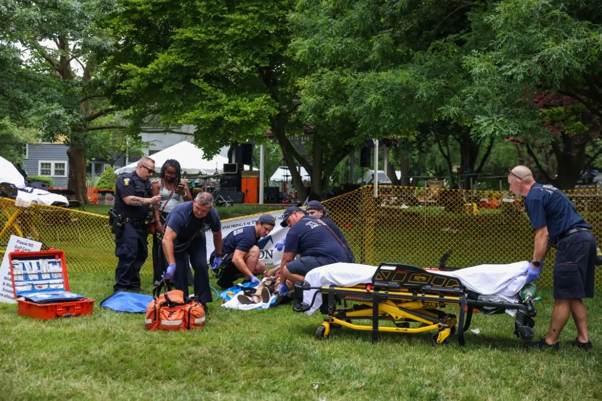 First responders help a woman who was injured the mass shooting that left 12 people injured at the Old West End Festival at the Agnes Reynolds Jackson Arboretum in Toledo on Saturday, June 6, 2026. (Rebecca Benson/The Blade via AP)