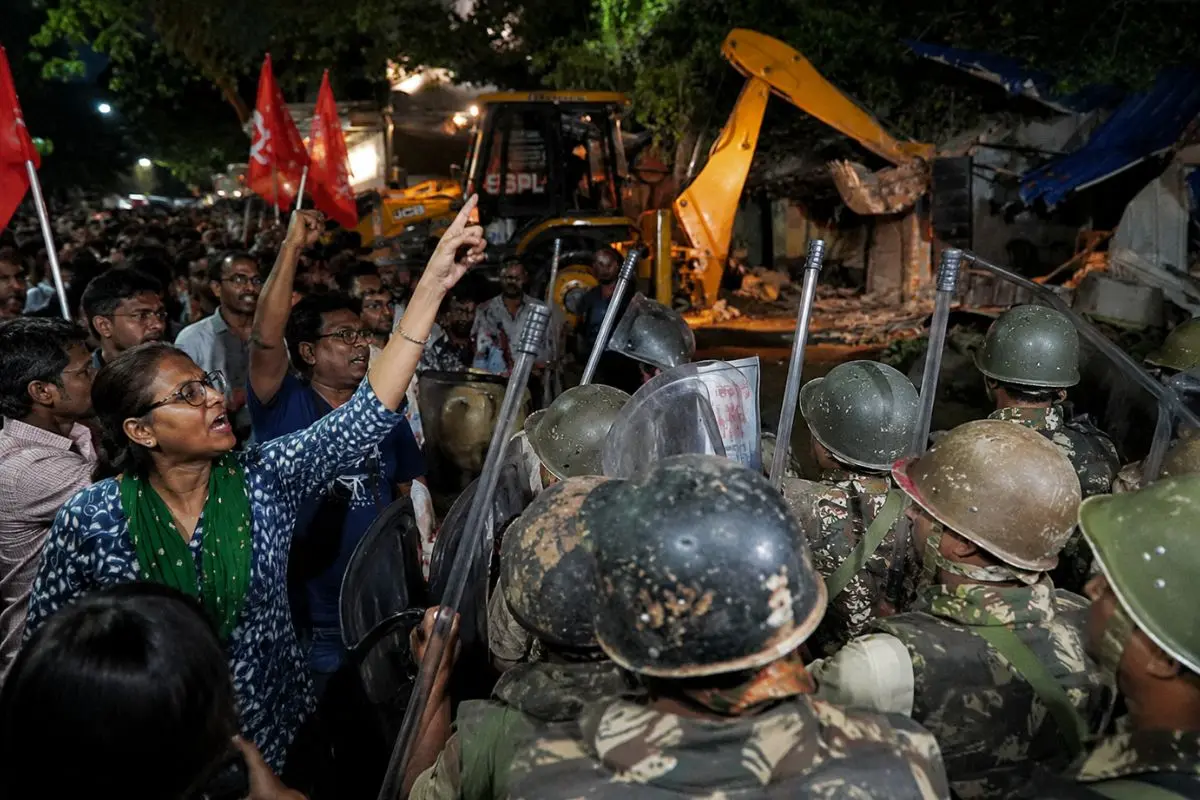 Police personnel stand guard as protesters oppose an overnight hawker eviction drive at Jadavpur railway station in Kolkata on Monday. The operation triggered demonstrations, allegations of a lathicharge, and the arrest of five people. (Photo: Canva)