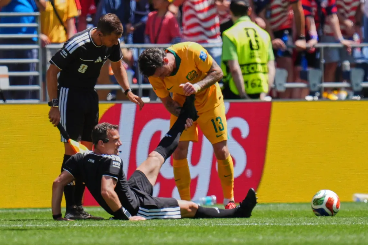 Germany's referee Felix Zwayer is assisted by Australia's Aiden O'Neill (13) during the World Cup Group D football match between the United States and Australia | Photo: AP