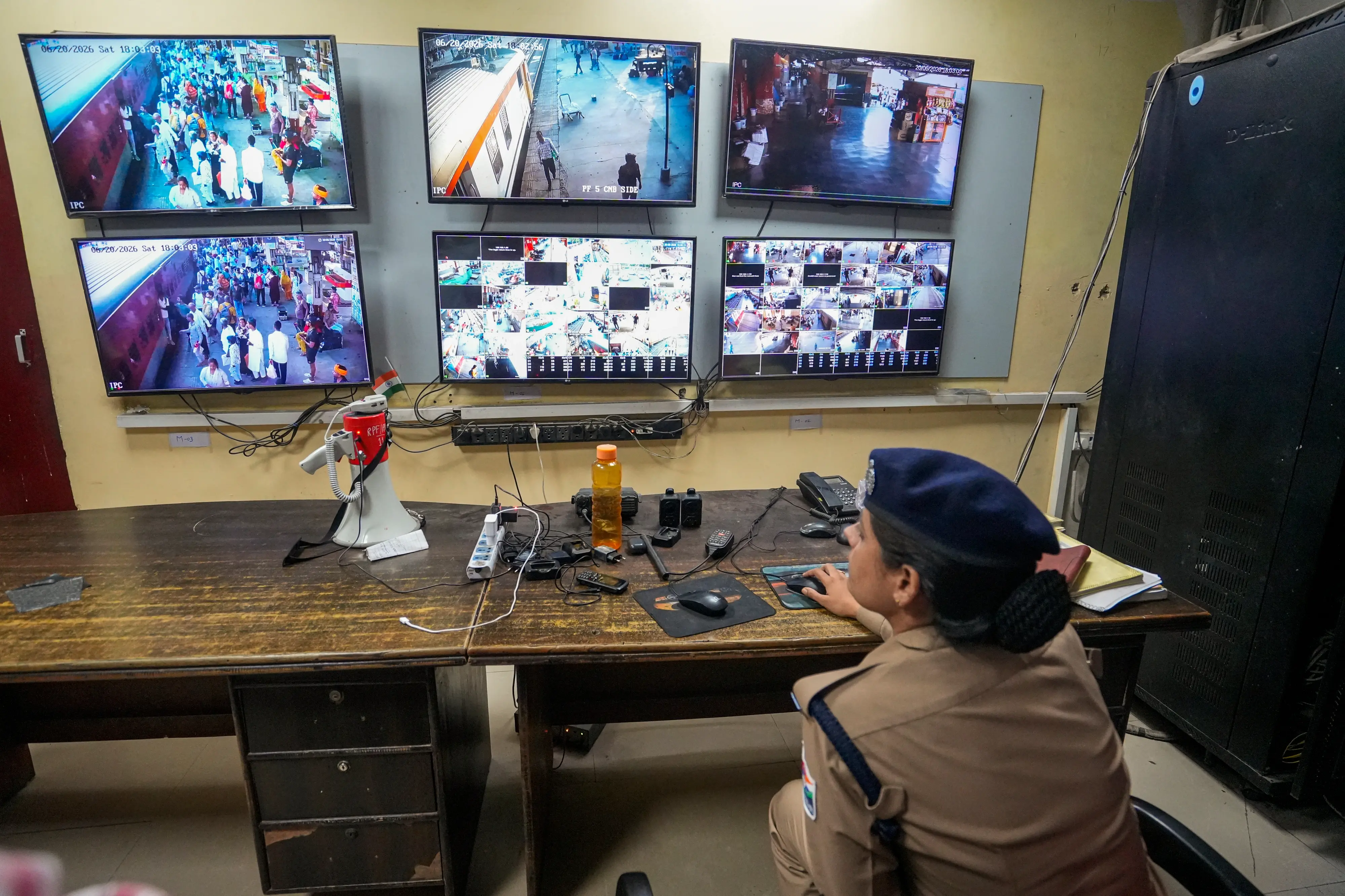 A police official keeps a vigil through CCTV cameras from a control room