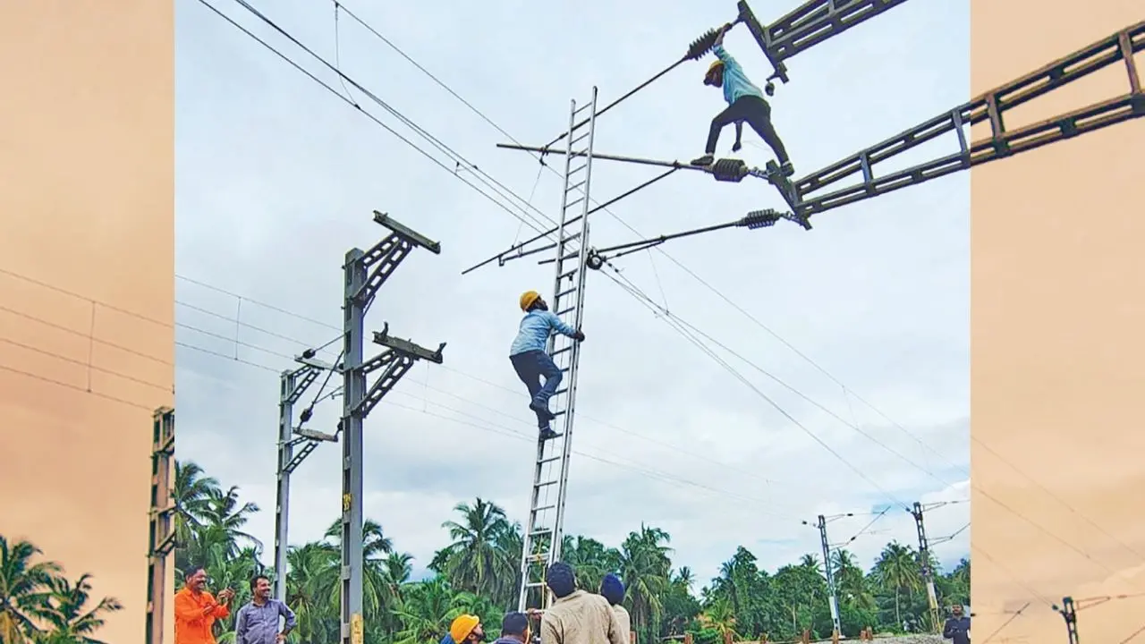 Railway officials repairing the snapped cables