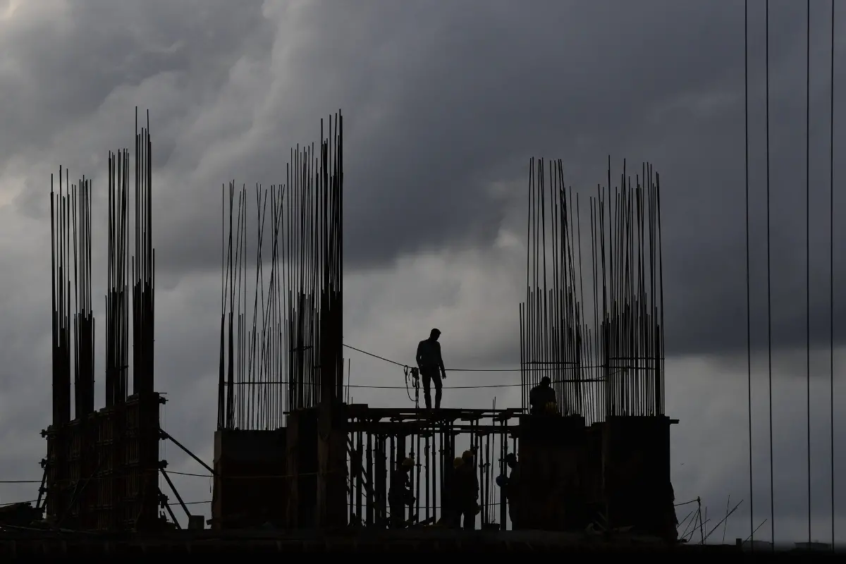 Workers at a construction site are silhouetted against the evening sky filled with pre-monsoon rain clouds in Kochi, southern Kerala state, India.| Photo: AP