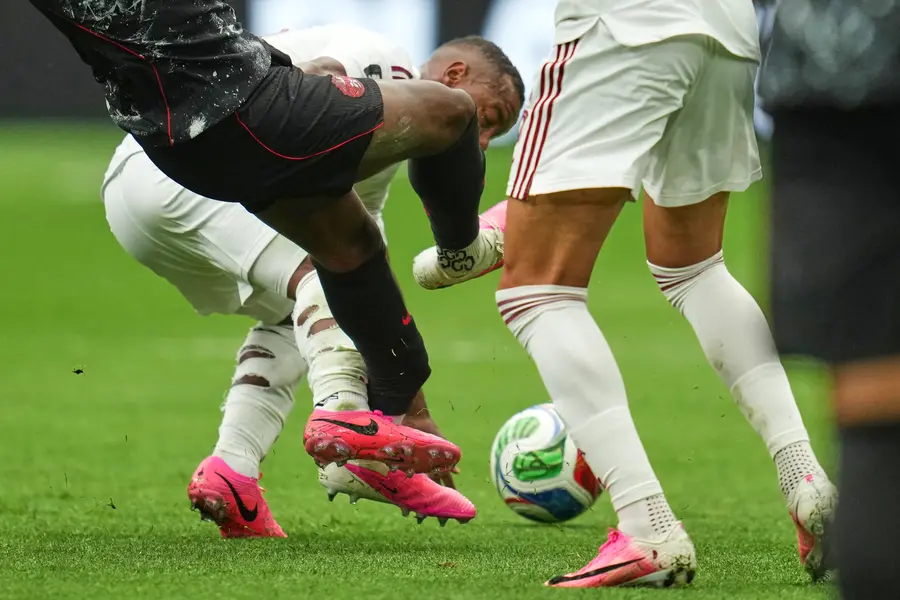 Canada's Ismael Kone, left, falls while being fouled against by Qatar's Assim Madibo during the World Cup Group B soccer match in Vancouver