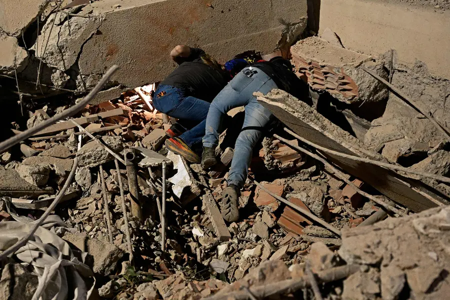 Rescue workers search through the rubble of a collapsed building in the Altamira neighbourhood following an earthquake in Caracas