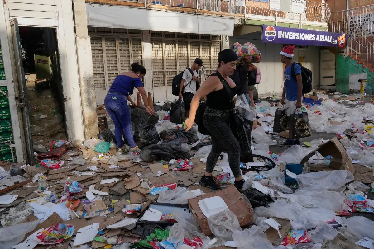 People take items from a supermarket in La Guaira, Venezuela, Friday, June 26, 2026, two days after twin earthquakes struck the country. (AP Photo/Ariana Cubillos)