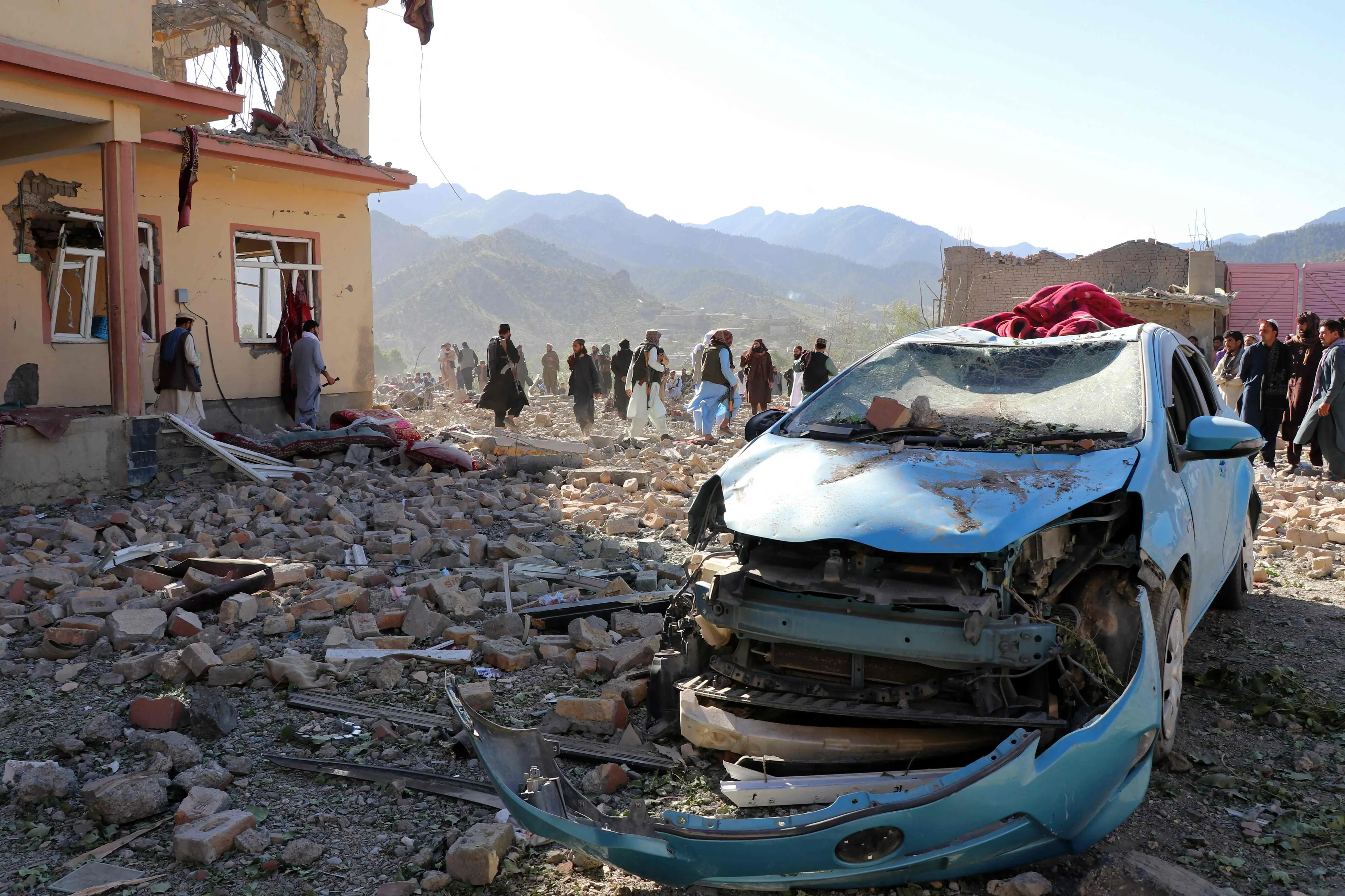 Afghan residents look at the remains of a building damaged in a Pakistani airstrike at a village in Afghanistan's Paktia province.| Photo: AFP