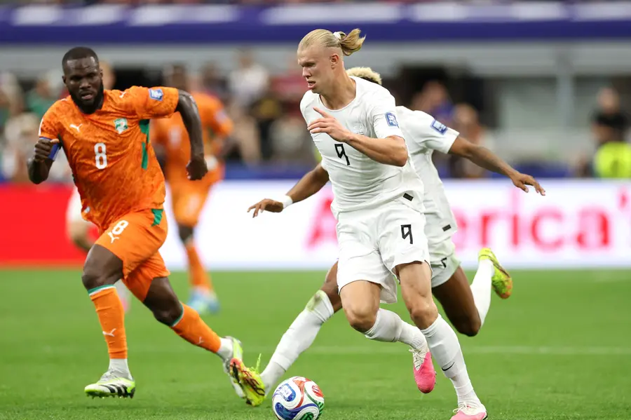 Erling Haaland of Norway runs with the ball under pressure from Franck Kessie of Cote d'Ivoire