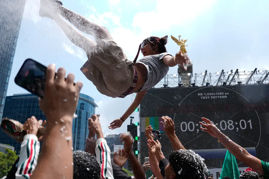 Soccer fans get revved up at a watch party on Reforma Ave., near the Angel of Independence monument, for the World Cup soccer match between Mexico and Ecuador