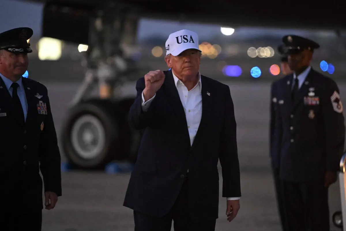 US President Donald Trump gestures toward reporters after disembarking from Air Force One at Joint Base Andrews, Maryland. | Photo: AFP
