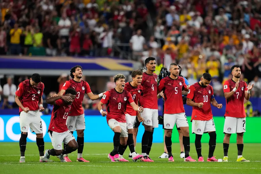 Egypt players react to teammate Mahmoud Saber scoring during a penalty shootout against Australia