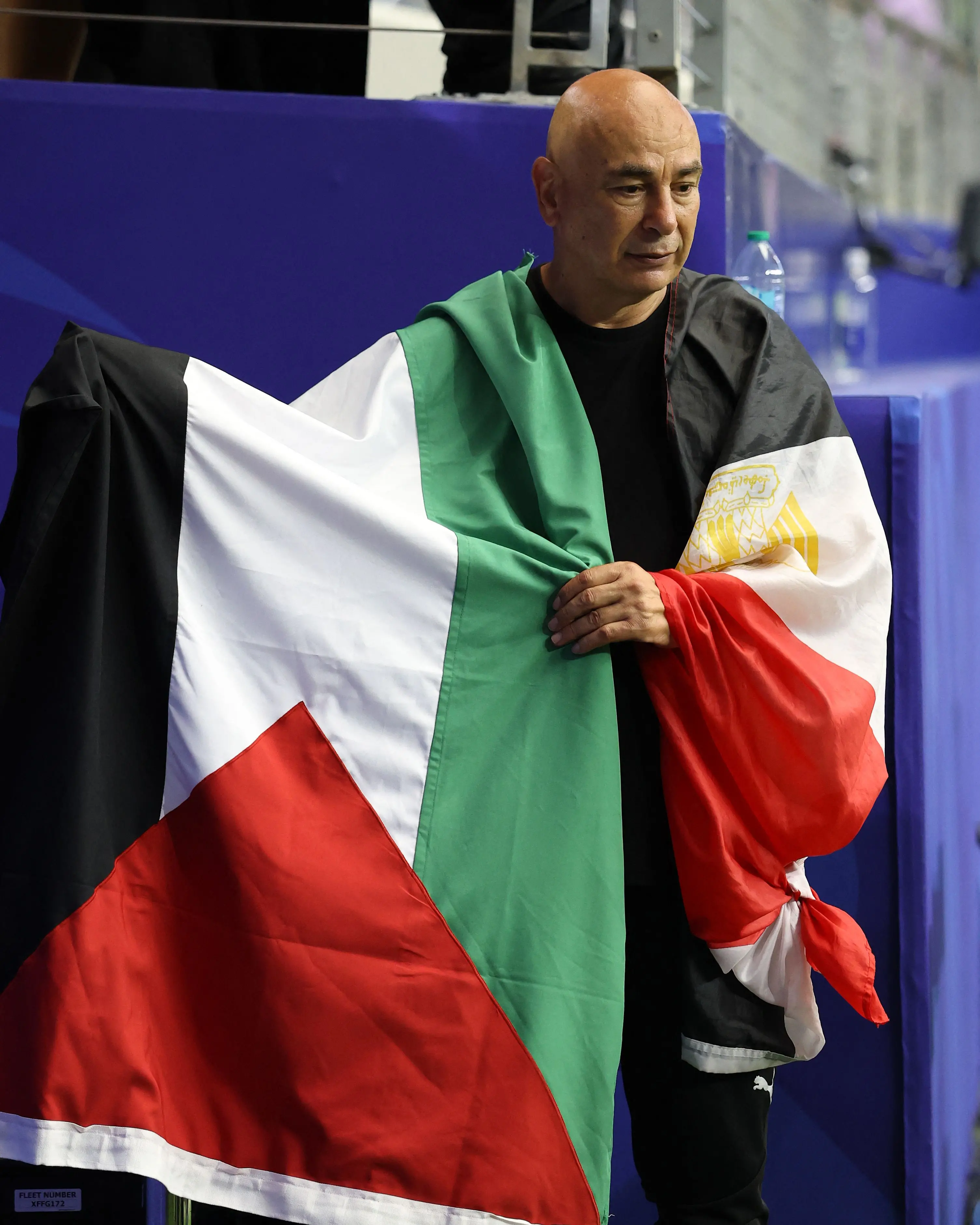 Hossam Hassan, Head Coach of Egypt, holds the flag of Palestine after the team's victory| Getty Images via AFP