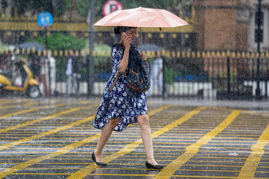 A woman walks amid rain in Mumbai