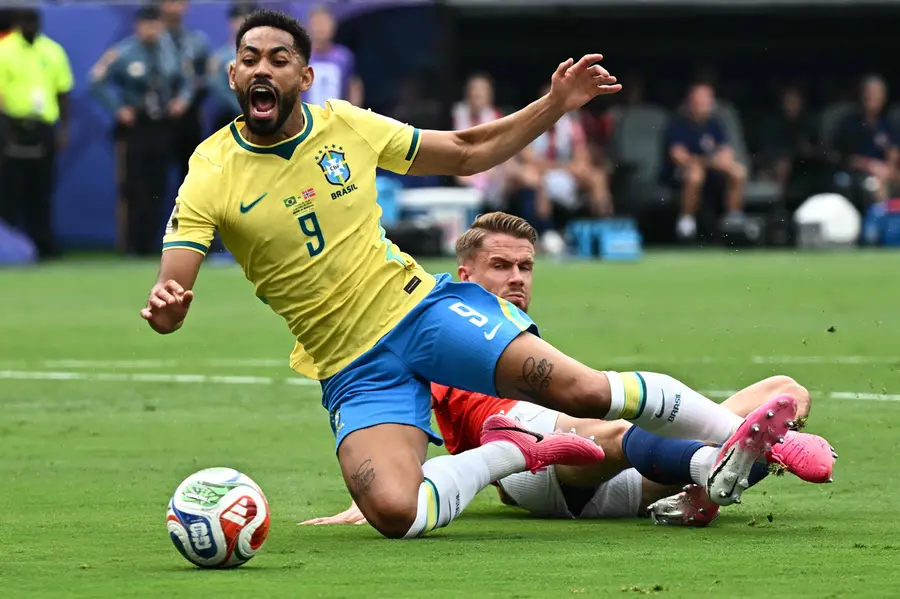 Brazil's forward Matheus Cunha is fouled by Norway's defenderKristoffer Vassbakk Ajer | AFP