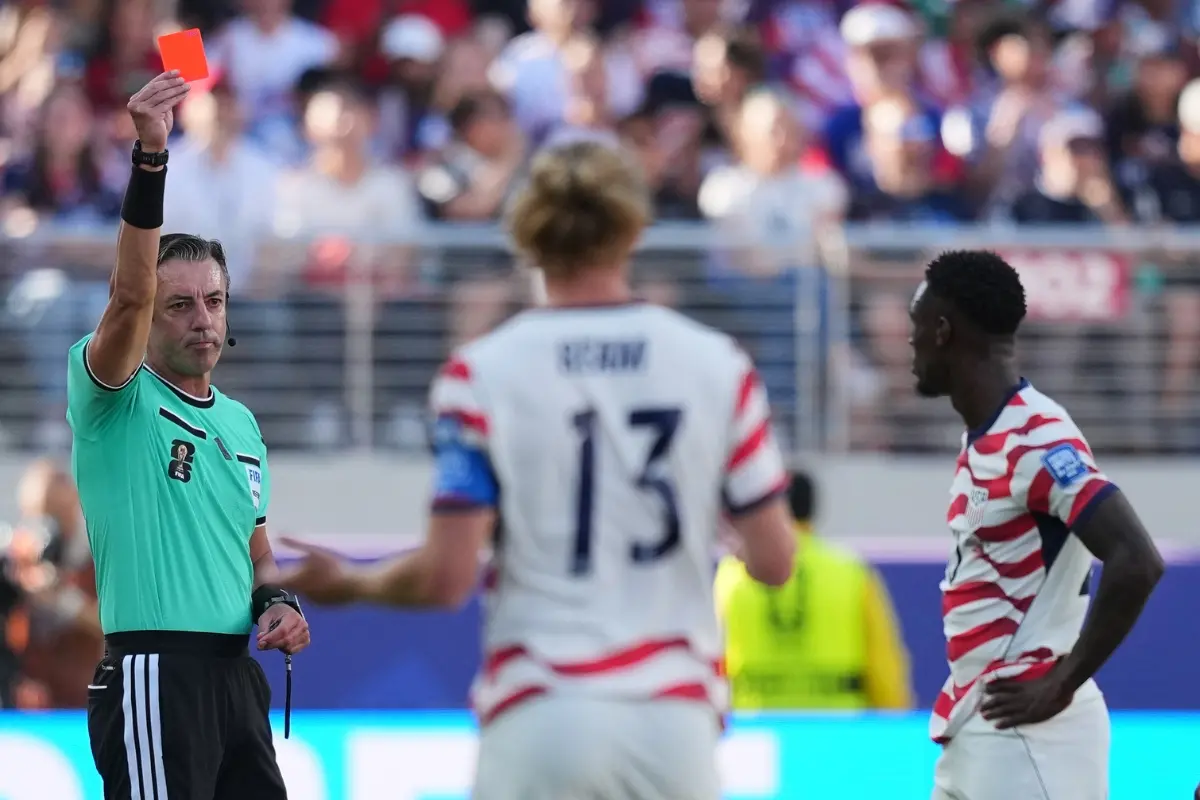 Referee Raphael Claus of Brazil shows a red card to United States' Folarin Balogun, right, during the World Cup round of 32 football match between the United States and Bosnia | Photo: AP