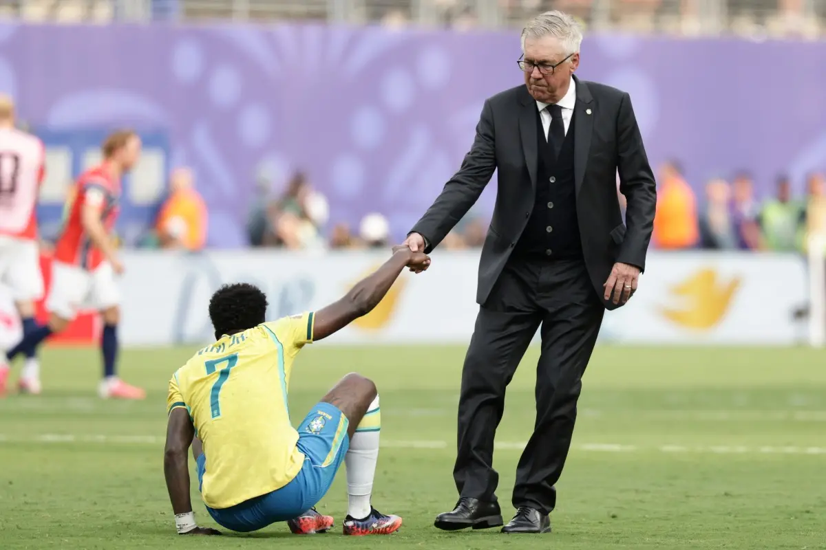 Brazil head coach Carlo Ancelotti helps Brazil's Vinicius Junior (7) get upduring the World Cup round of 16 soccer match between Brazil and Norway in East Rutherford, N.J., near New York. | Photo: AP