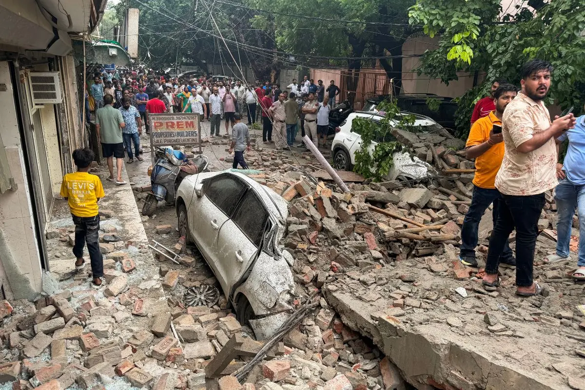 A view of a damaged vehicle trapped under the piles of rubble after an under-construction building collapsed at Rohini's Sector 16, in New Delhi on Wednesday. Firefighting and rescue operations underway. (ANI Photo)