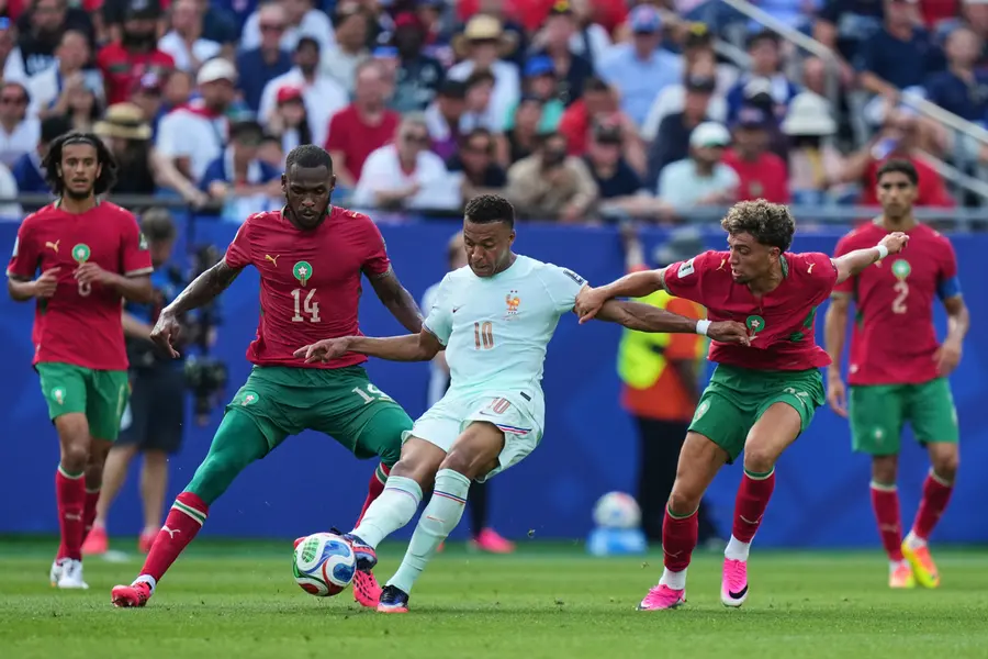 Mbappe makes a pass as Issa Diop and Neil El Aynaoui, right, defend during the World Cup quarterfinal match between France and Morocco