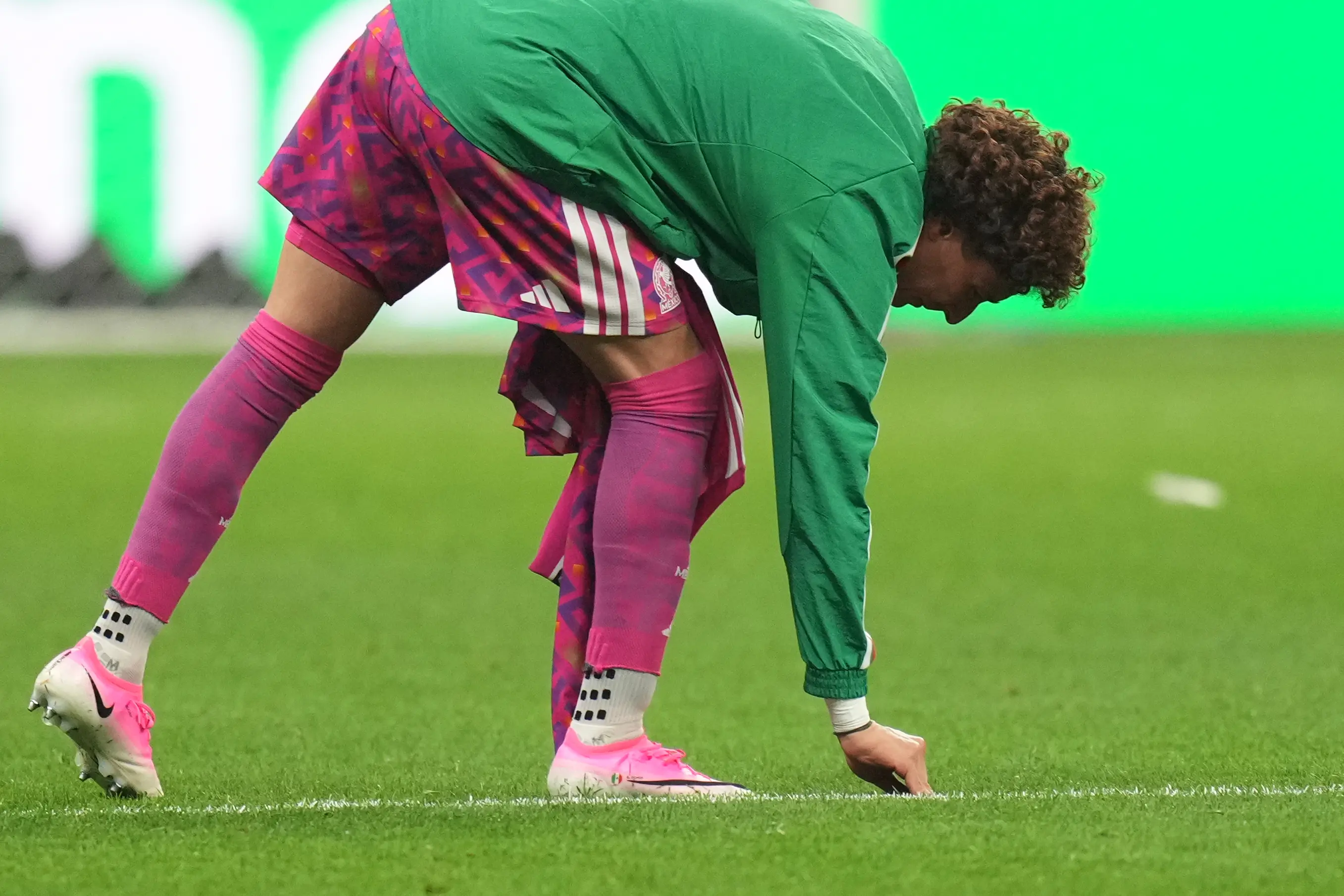Mexico retiring goalkeeper Guillermo Ochoa touches the grass before leaving the pitch at the end of the World Cup round of 16 soccer match | AP