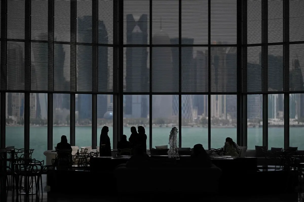 Visitors to the Museum of Islamic Art are seen in front of the skyline of highrise buildings in Doha (File photo: AFP)