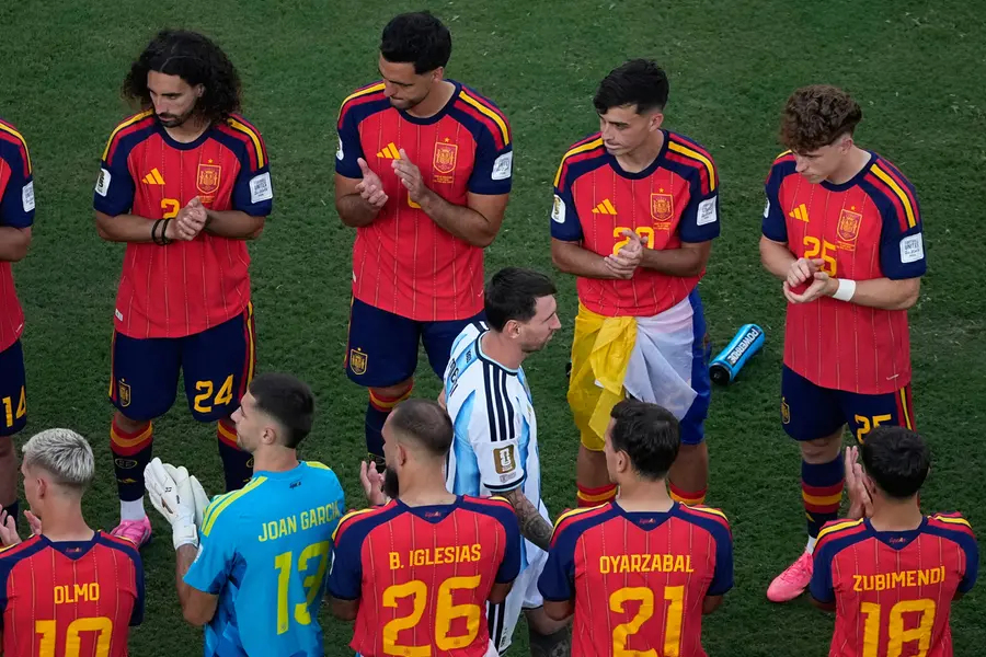 Lionel Messi walks between Spain players during the medal ceremony after the World Cup final match between Spain and Argentina