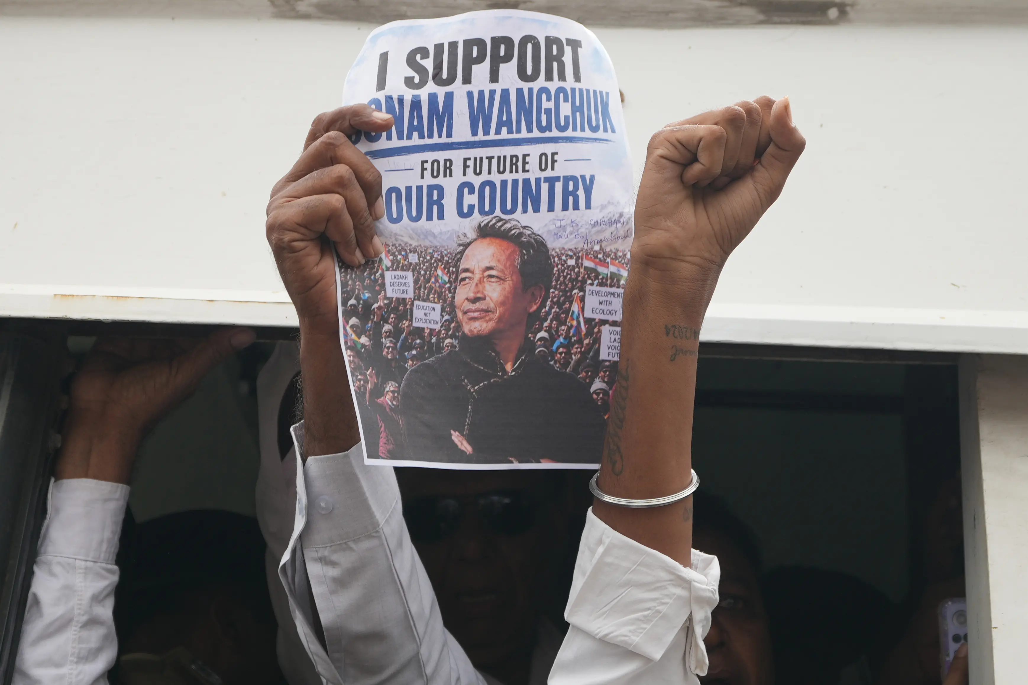 A protester holds a poster featuring educationist and activist Sonam Wangchuk | AP