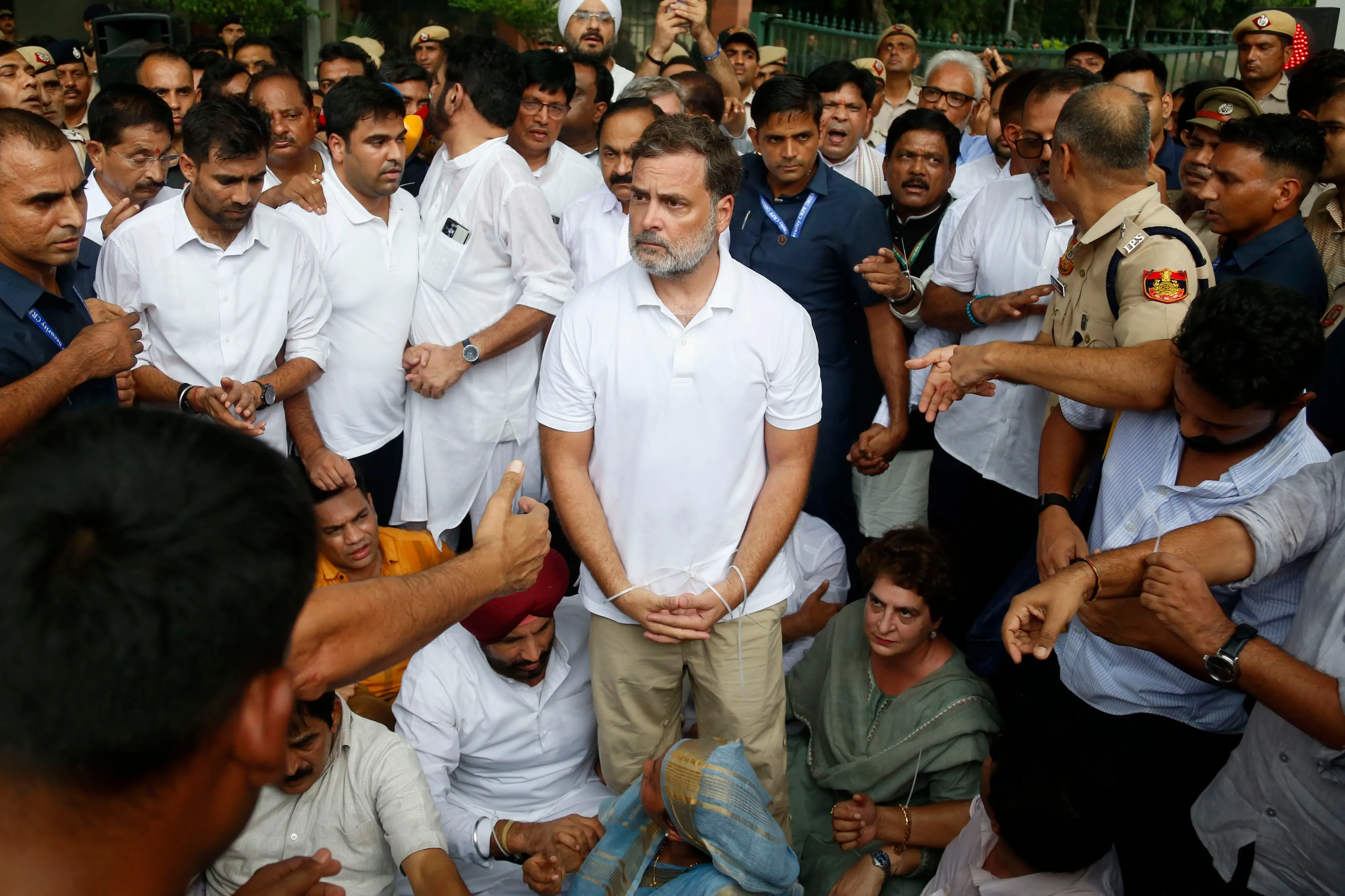 India's opposition Congress party leader Rahul Gandhi, center, with his hands tied, participates in a sit-in protest with his sister and lawmaker Priyanka Gandhi Vadra, center right, outside the residence of Prime Minister Narendra Modi in New Delhi.| Photo: AP