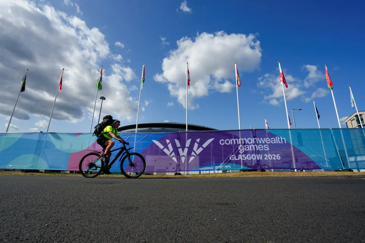 A cyclist passes participating nations' flags ahead of the Commonwealth Games 2026, in Glasgow, Scotland | Photo: PTI