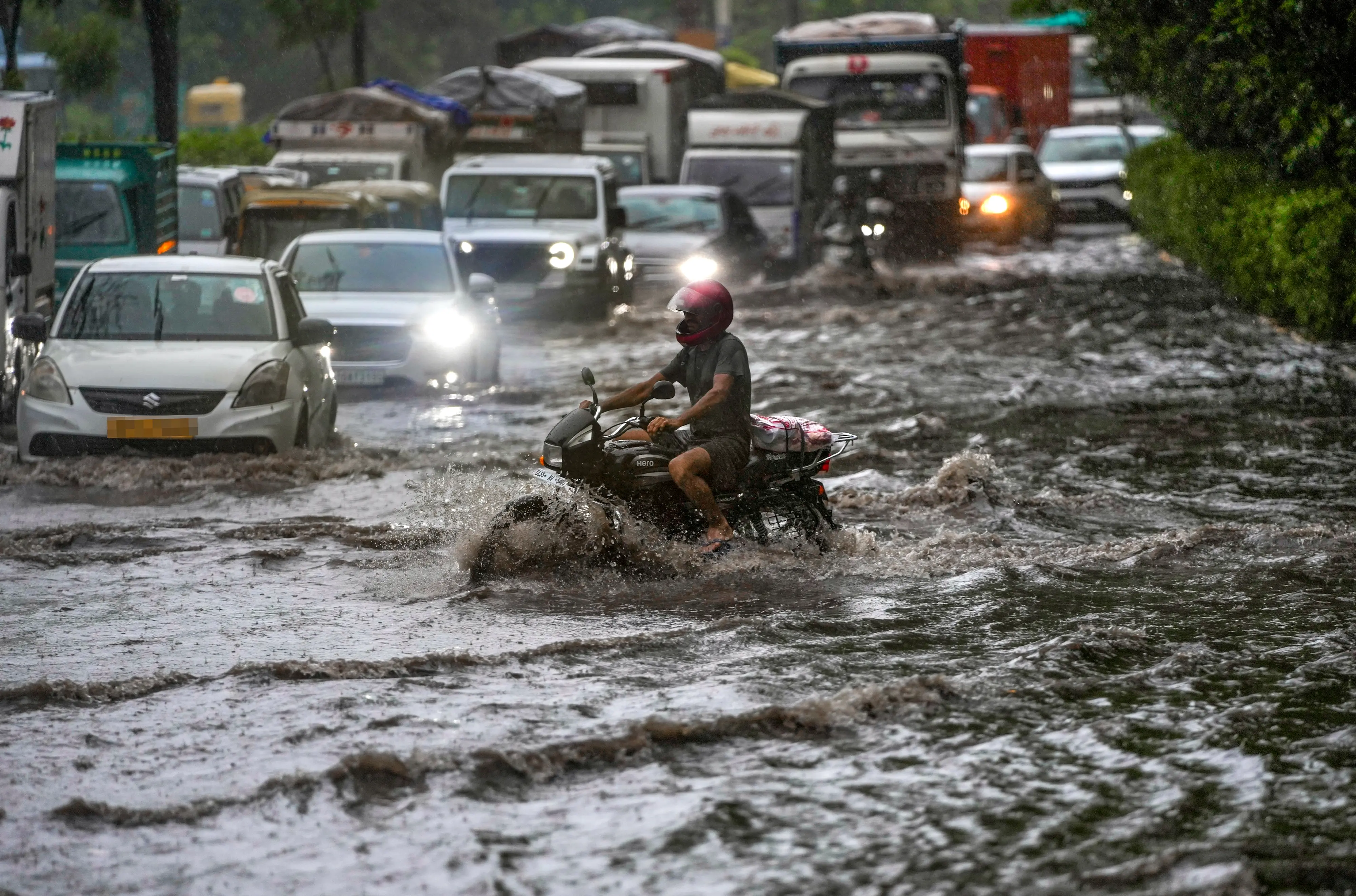 Vehicles move through a waterlogged road amid heavy rain, in the ITO area, New Delhi.| Photo: PTI