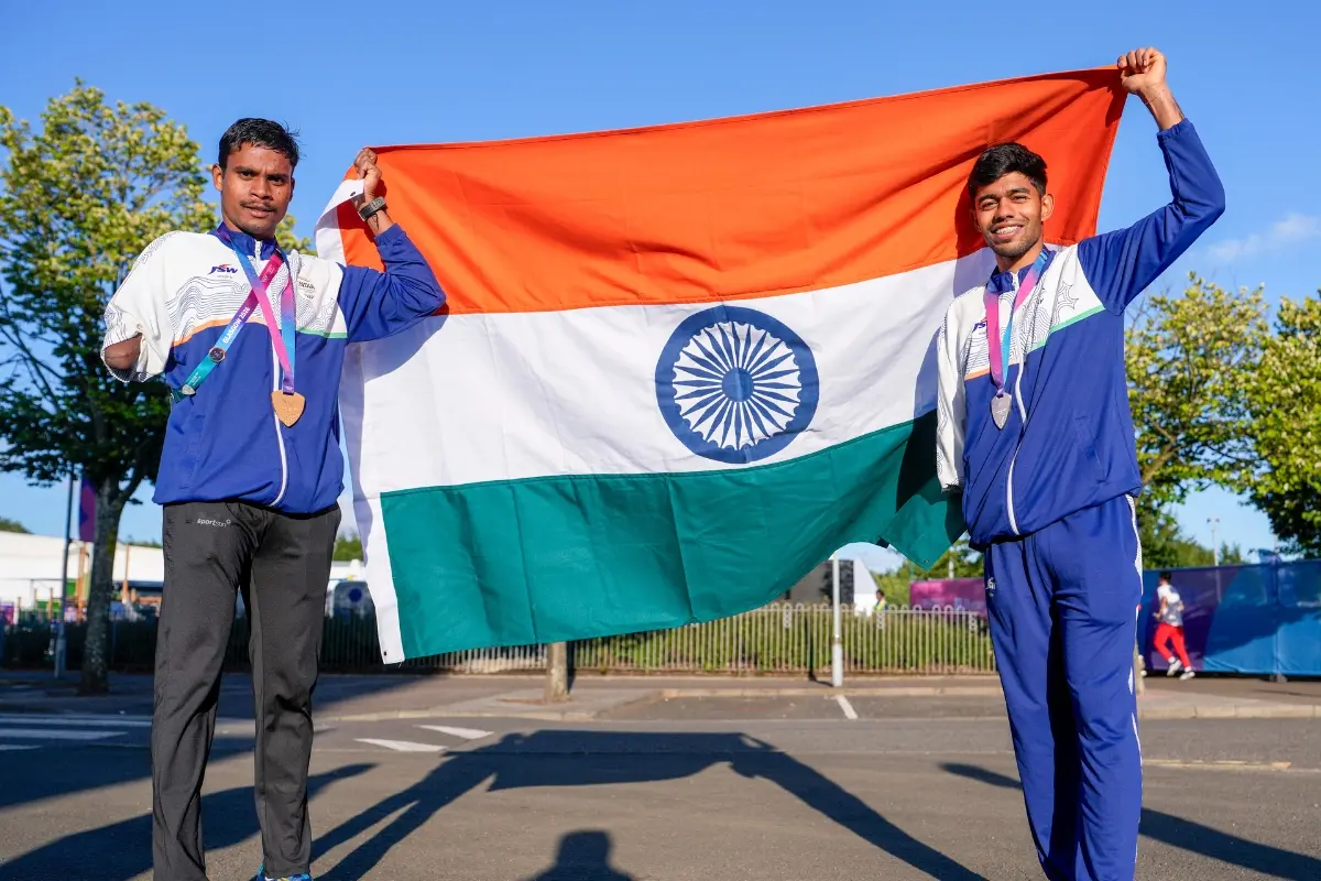 India's Dilip Mahadu Gavit, left, gold medallist, and Mohammed Basil Morssinganakath, silver medallist, pose with the national flag after finishing first and second in the Men's 100m T47 para-athletics event at the Commonwealth Games 2026, in Glasgow, Scotland | Photo: PTI