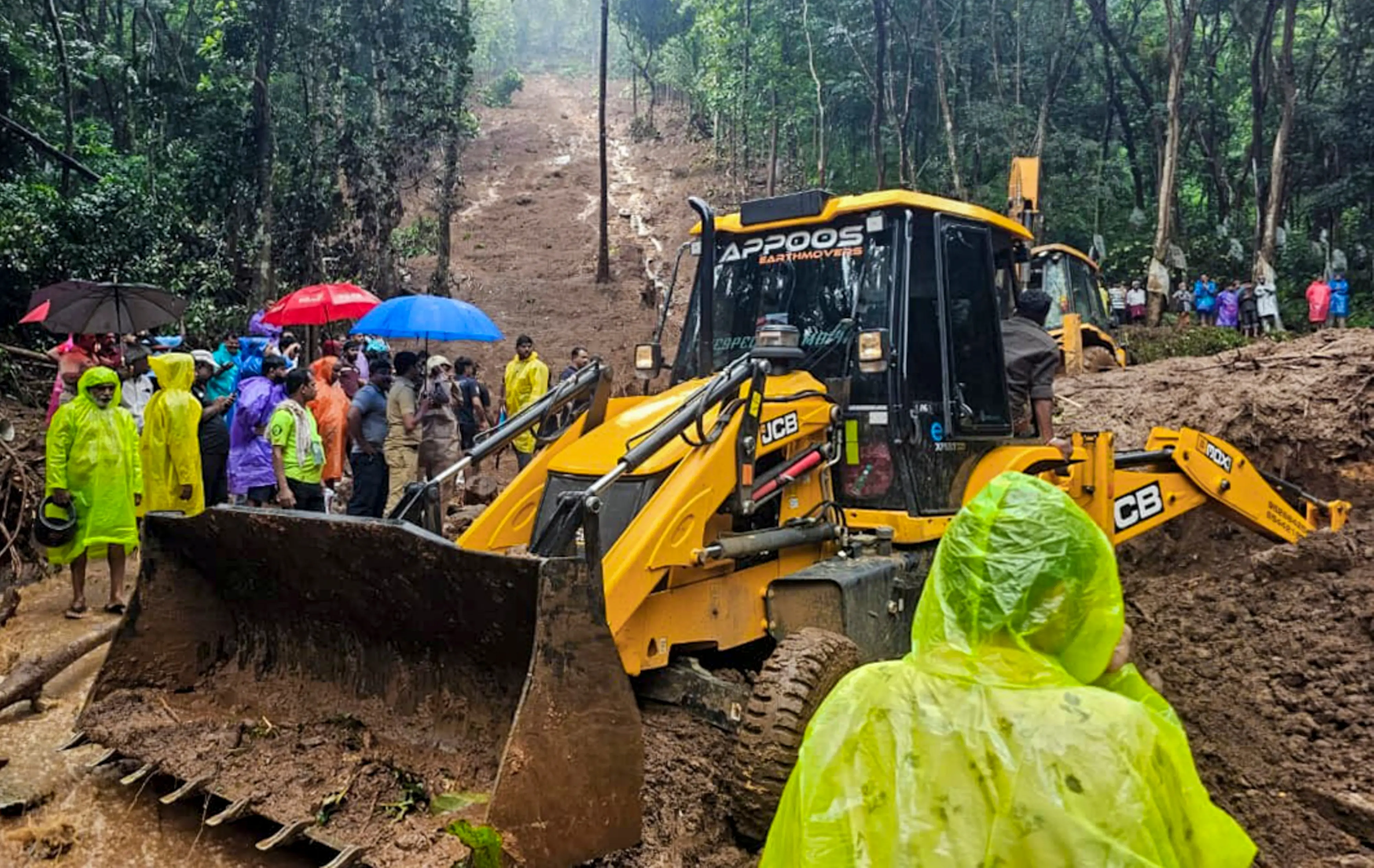 Rescue personnel and people during a rescue operation following a landslide due to rain triggered floods, in Kottayam