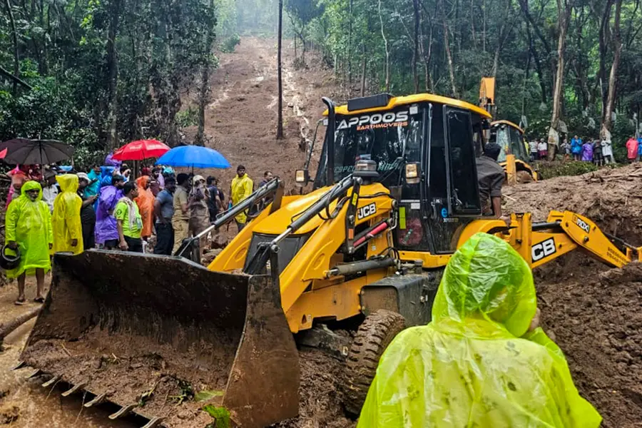 Rescue personnel and people during a rescue operation following a landslide due to rain triggered floods, in Kottayam